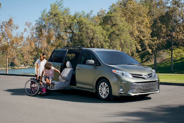 2019 Toyota Sienna A woman helping a child into her wheel chair from the handicap accessible seat on the 2019 Toyota Sienna