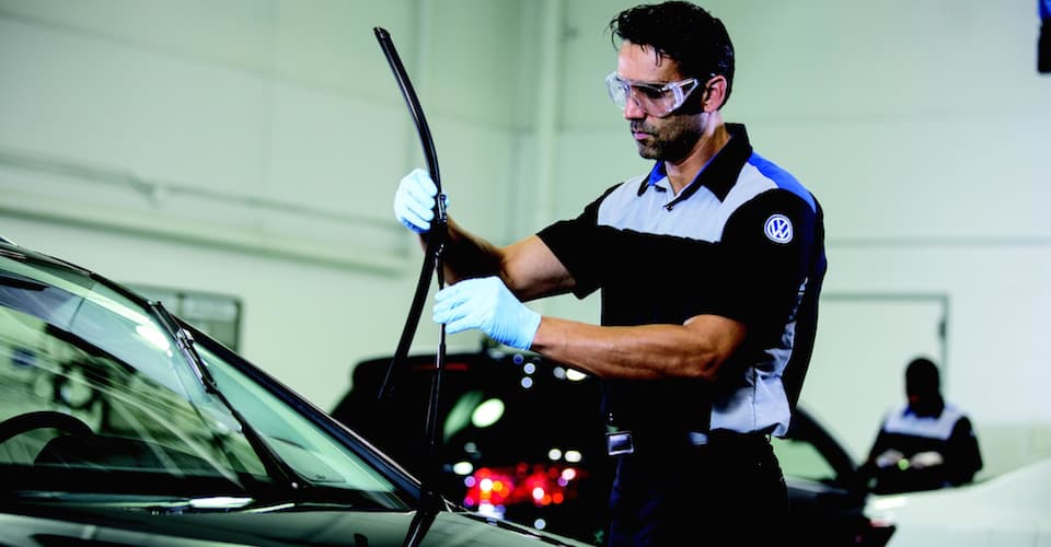 A Volkswagen technician replacing wiper blades