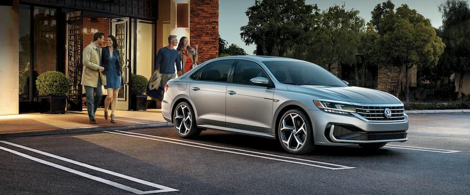 A silver 2019 Volkswagen passat parked outside of a restaurant