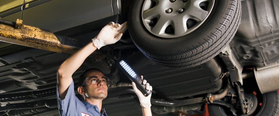 A service technician inspecting the wheel on a vehicle