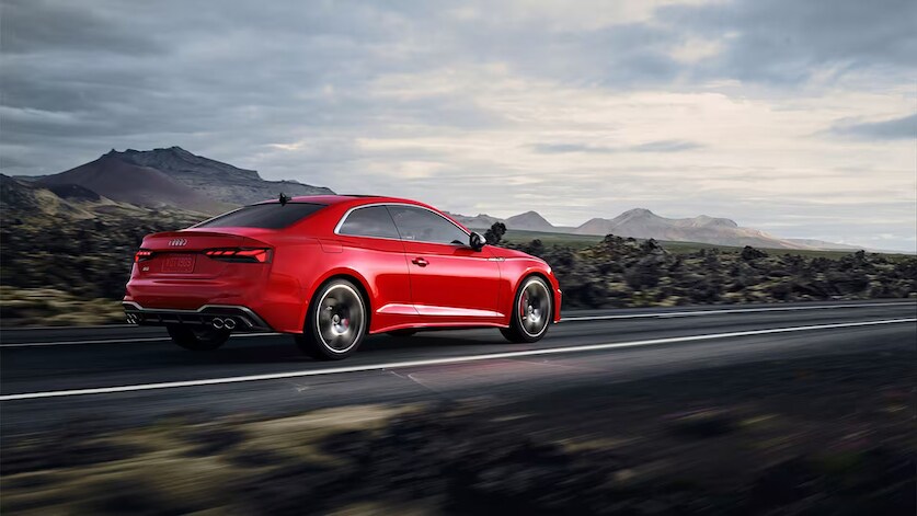 vue latérale arrière d'une Audi S5 Coupé 2023 roulant sur route ouverte.