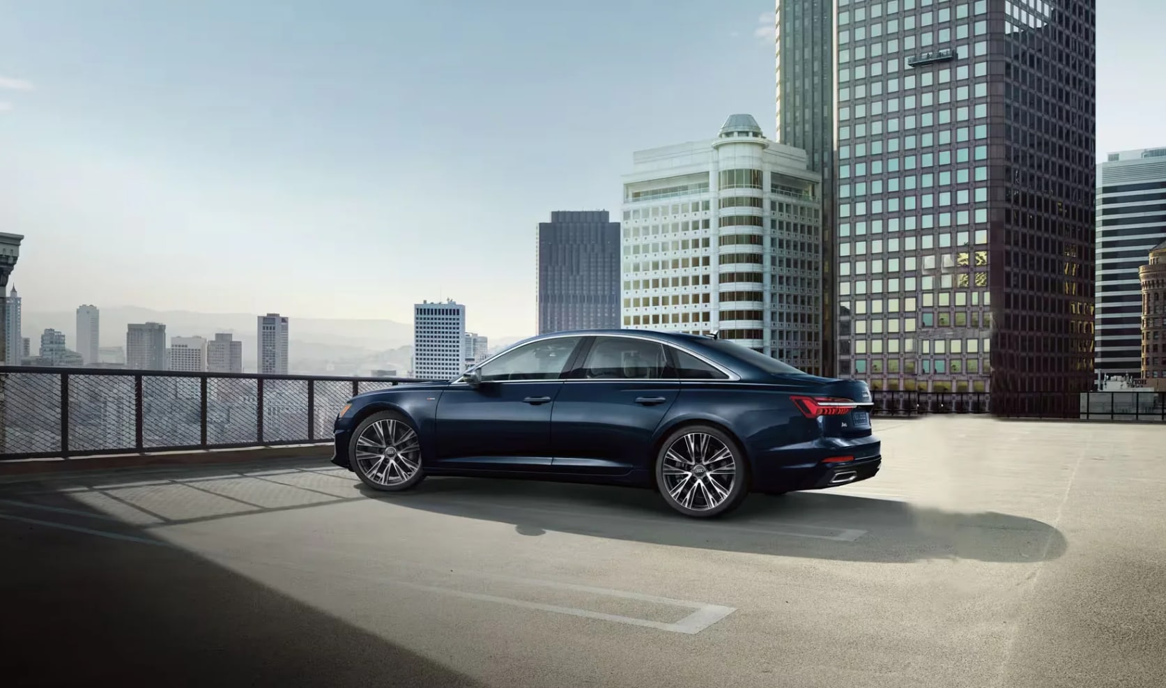 vue latérale arrière d'une Audi A6 2023 bleue dans un stationnement
