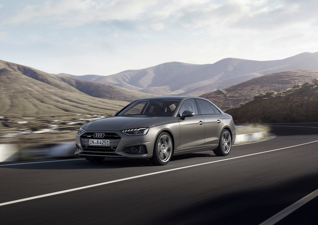 L'Audi A4 Berline gris Daytona roulant sur une route.