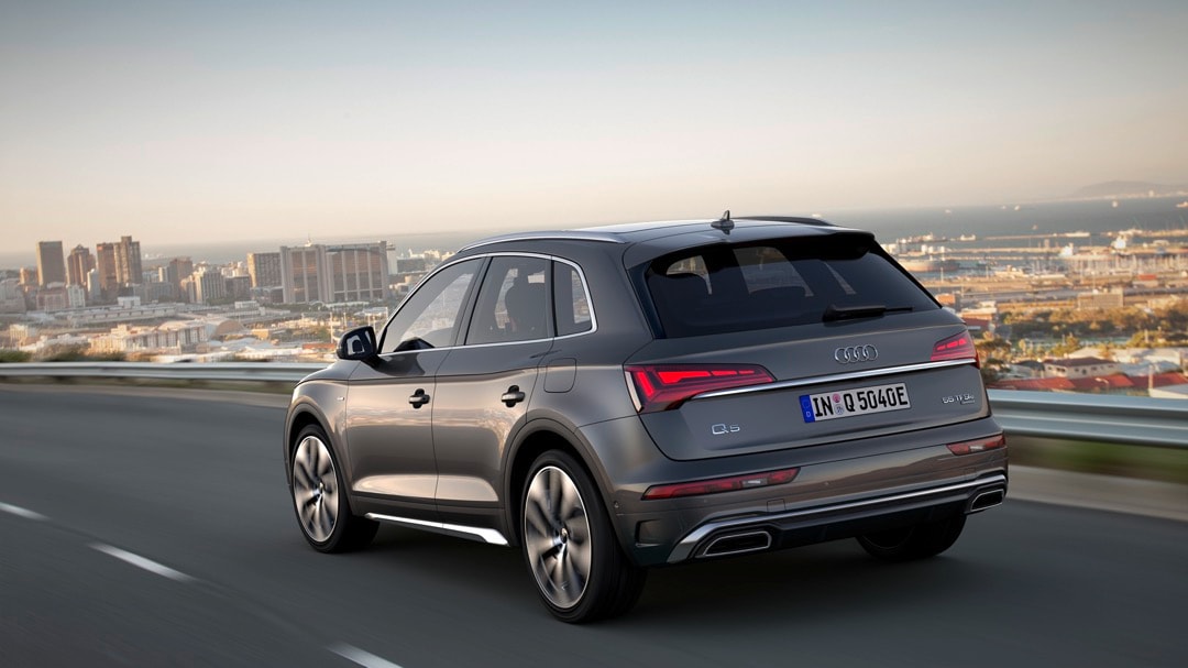 Vue 3/4 arrière de l'Audi Q5 Gris Chronos Métallisé roulant sur une route.