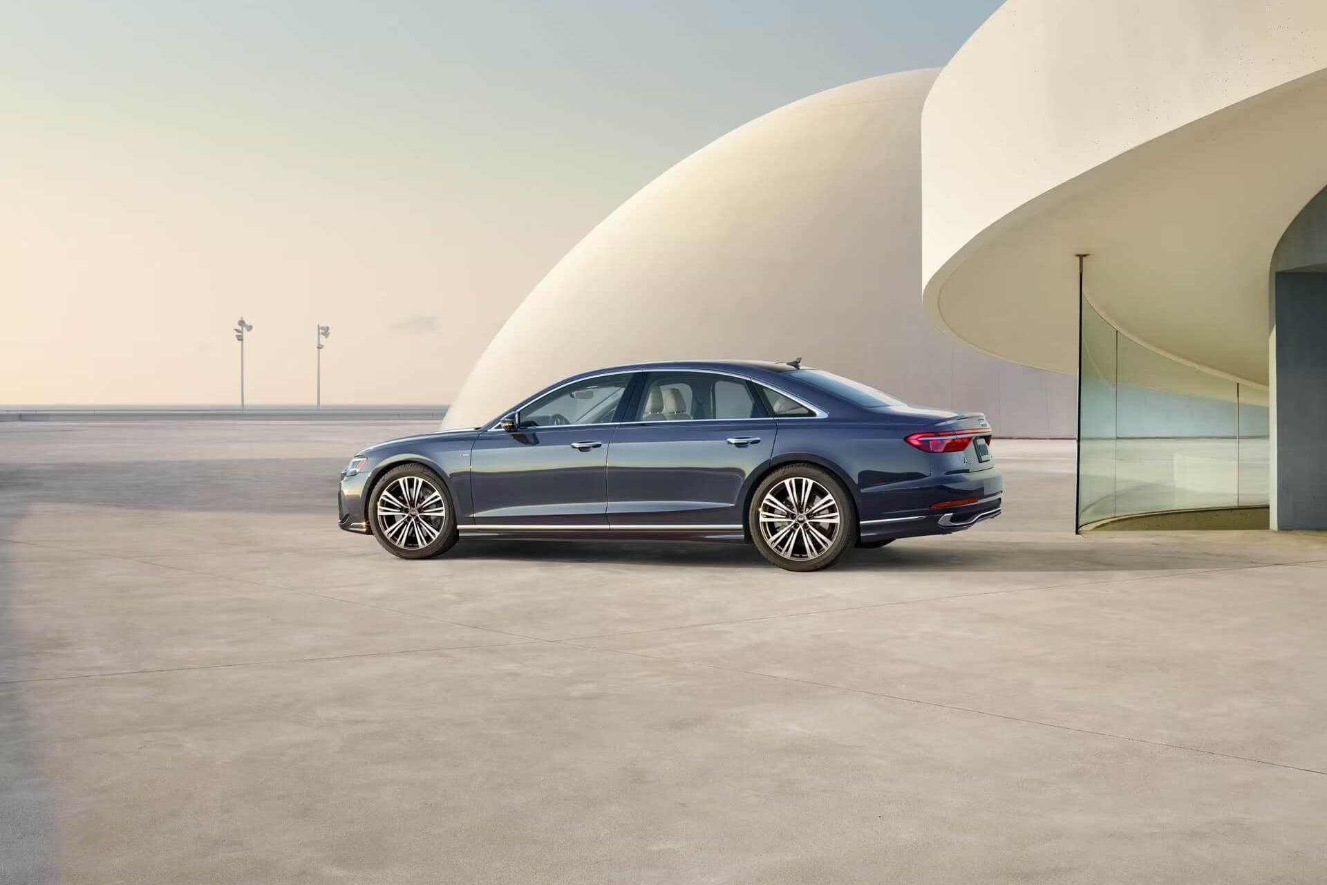 Vue latérale et 1/4 arrière du Audi A8 à l'extérieur.