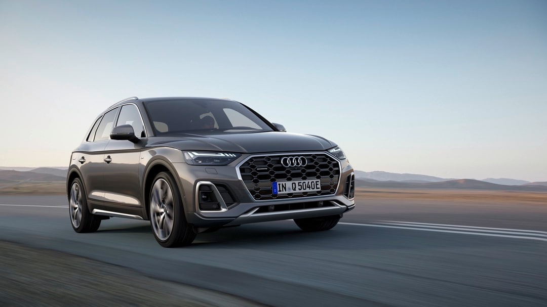 Vue 3/4 avant de l'Audi Q5 Gris Chronos Métallisé roulant sur une route.