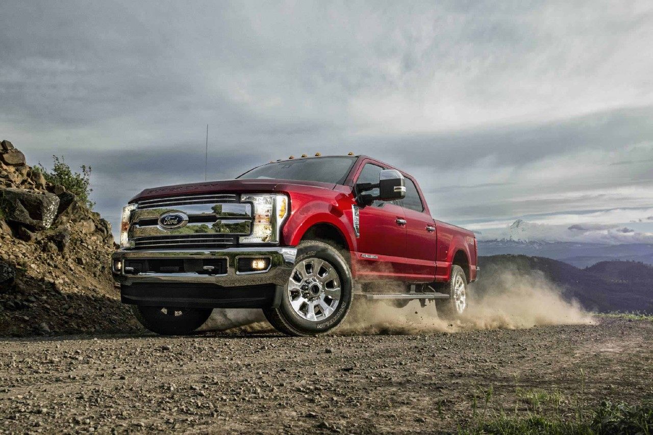 New Burgundy 2018 Ford F250 Pickup Truck Driving Down Gravel Road