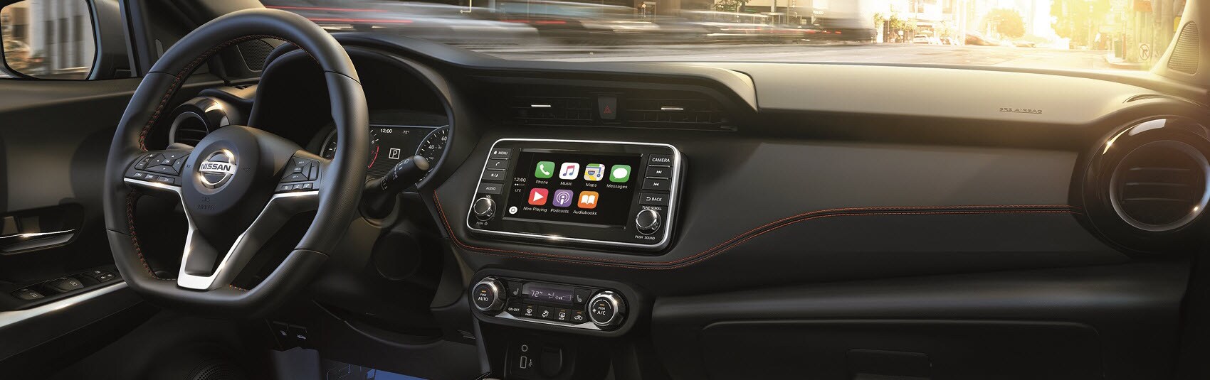 Nissan Kicks with black Interior showing Apple Car Play on display along with steering wheel and dashboard