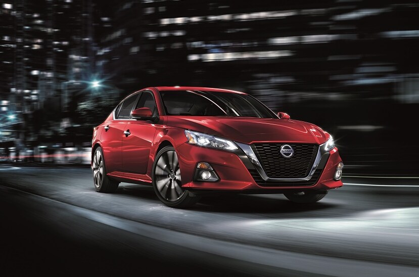 Red Nissan Altima MPG on a city street shot from front.