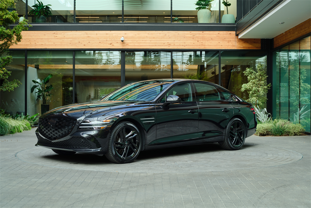 Black Genesis G80 parked outside of modern home.