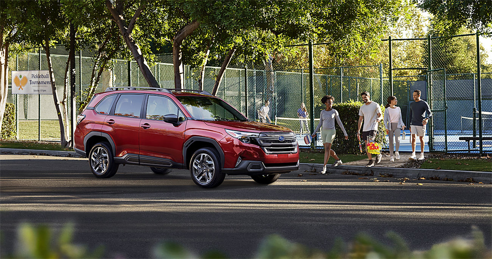 Red 2026 Subaru Forester parked outside of tennis courts with friends.