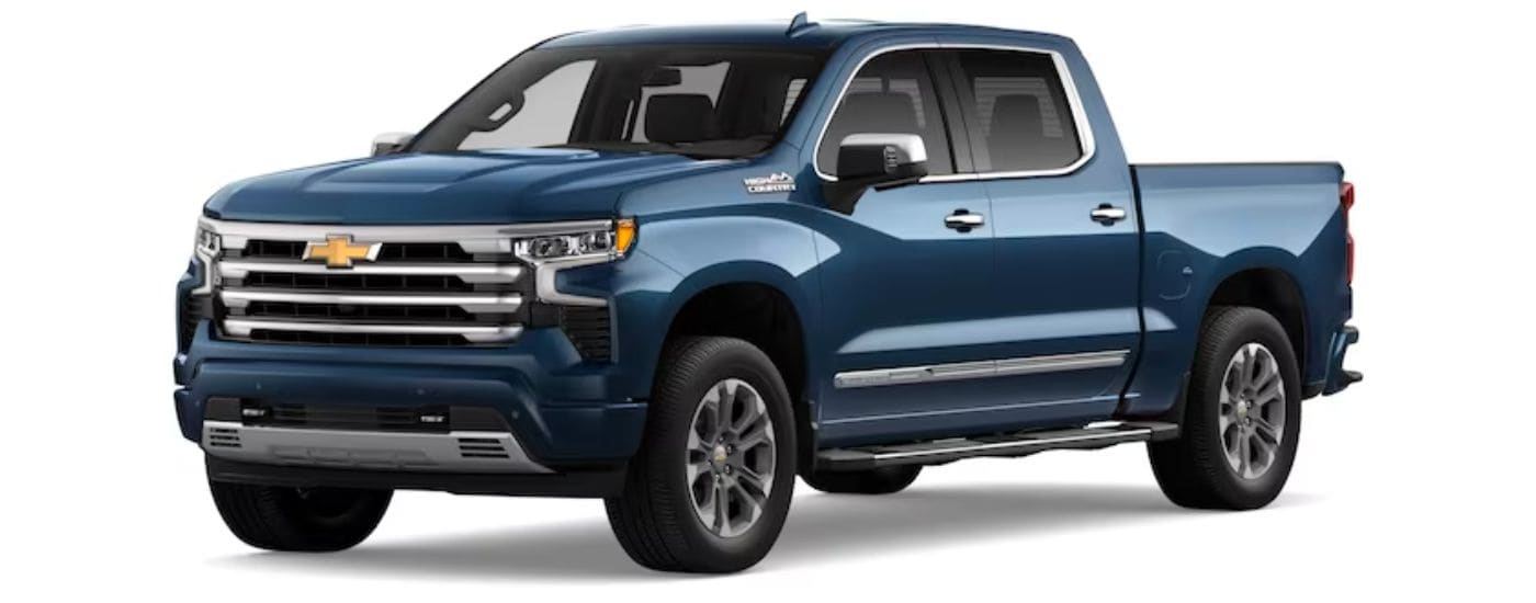 A blue 2024 Chevy Silverado 1500 High Country is shown angled left.
