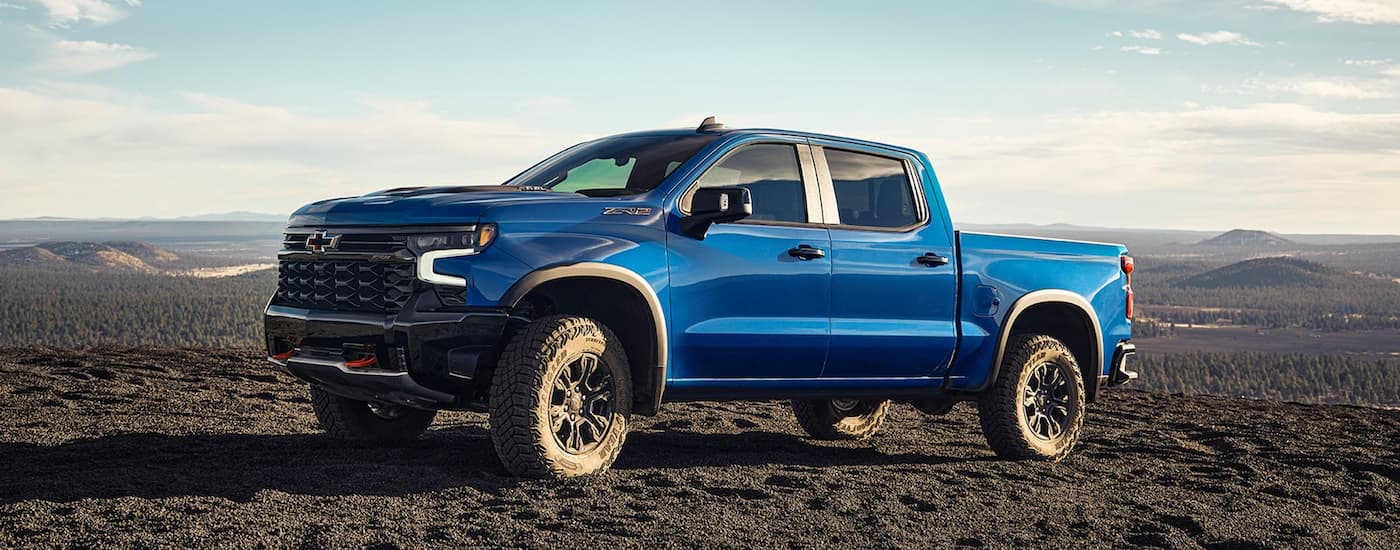 A blue 2022 Chevy Silverado 1500 ZR2 parked on a gravelly mountaintop.