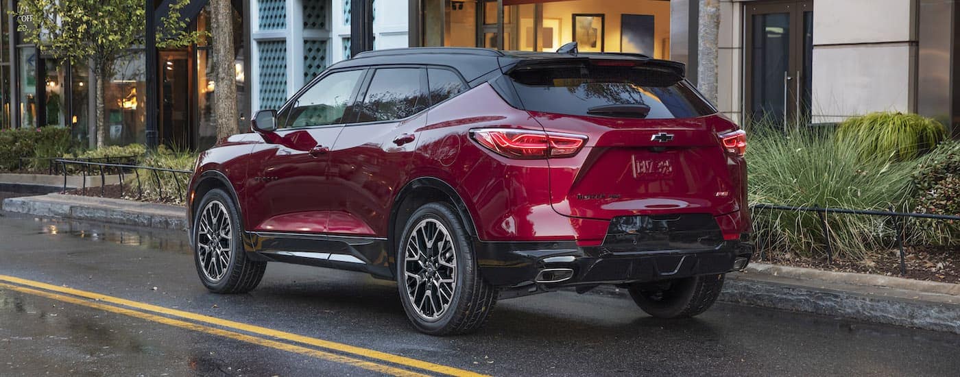 A red 2023 Chevy Blazer RS is shown from the rear on a city street.
