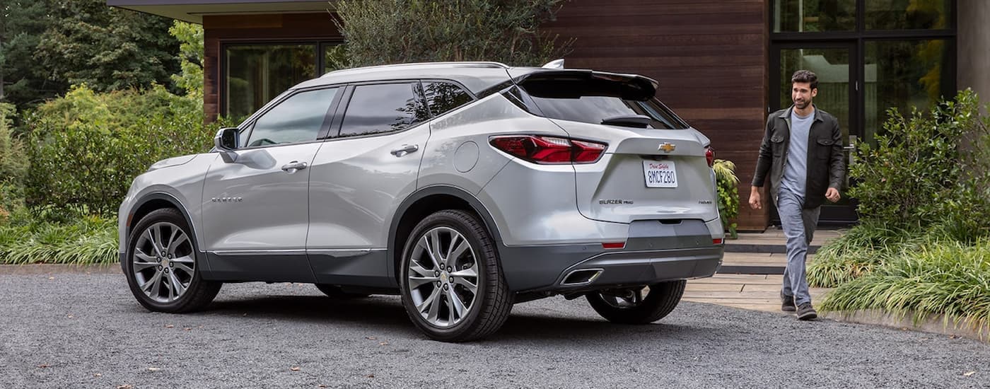 A grey 2022 Chevy Blazer parked in the driveway of a modern home.
