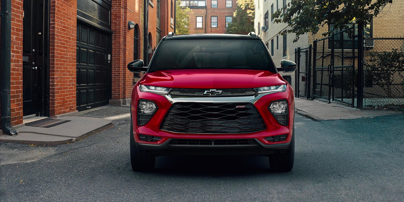A red 2022 Chevy Trailblazer RS parked between brick buildings in a city alleyway 