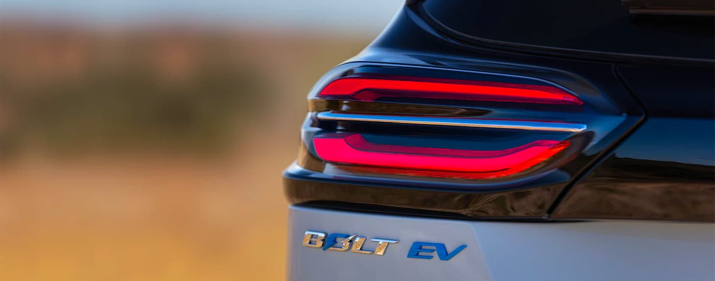 A close up shows the drivers side taillight and badging on a silver 2022 Chevy Bolt EV.
