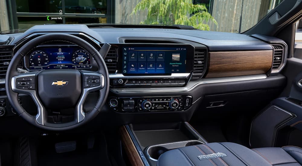 The black and brown interior of a 2024 Chevy Silverado 3500 HD High Country with digital dash and infotainment screen