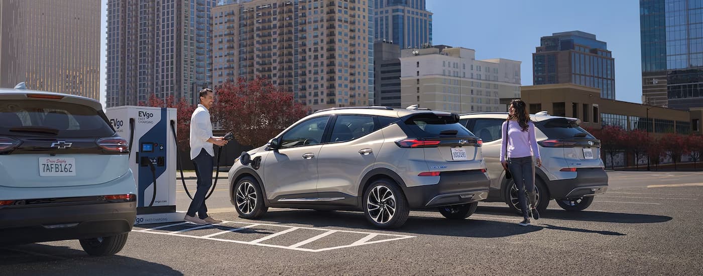 A silver 2023 Chevy Bolt EUV parked at a public charging station.