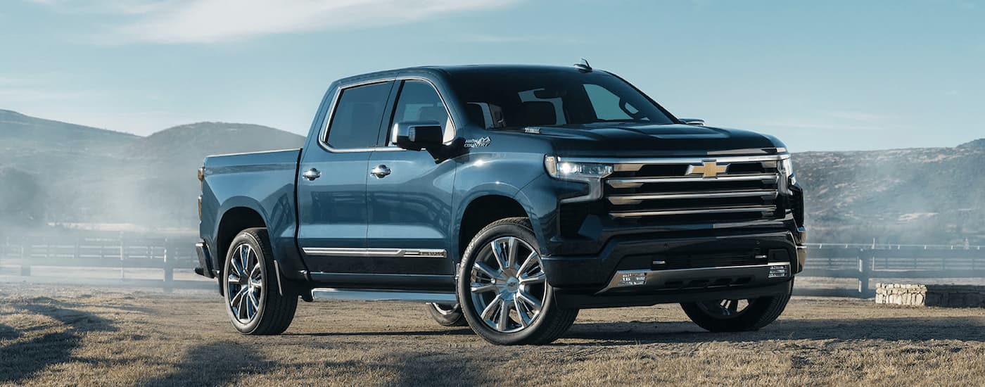 A blue 2022 Chevy Silverado 1500 High Country parked on a farm.