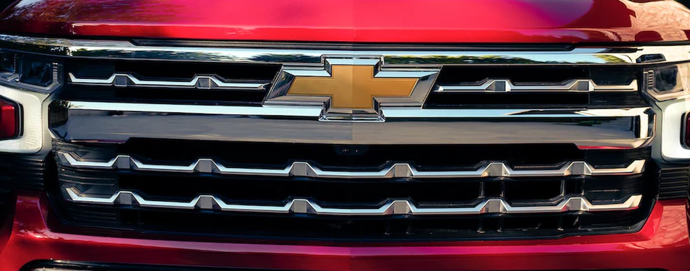 A close up of the grille on a red 2022 Chevy Silverado 1500 is shown.