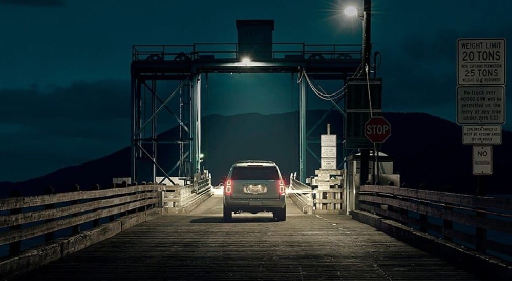 A silver 2020 Chevy Tahoe is shown from the rear at night.