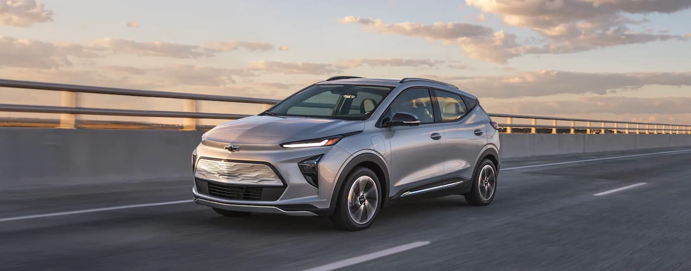 A silver 2023 Chevy Bolt EUV is shown driving over a bride.