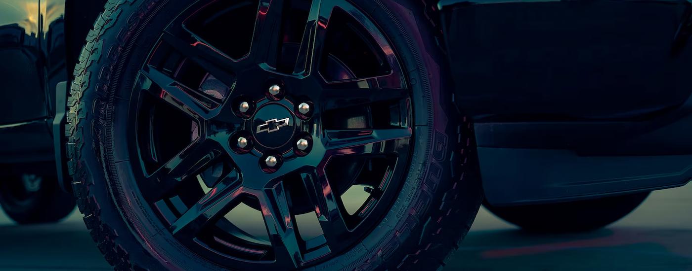 A close up of the rim on a  black 2023 Chevy Silverado 1500 Custom is shown.