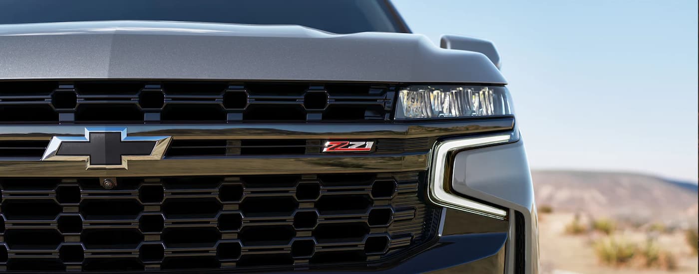 A close up shows the driver side headlight on a grey 2022 chevy suburban Z71.