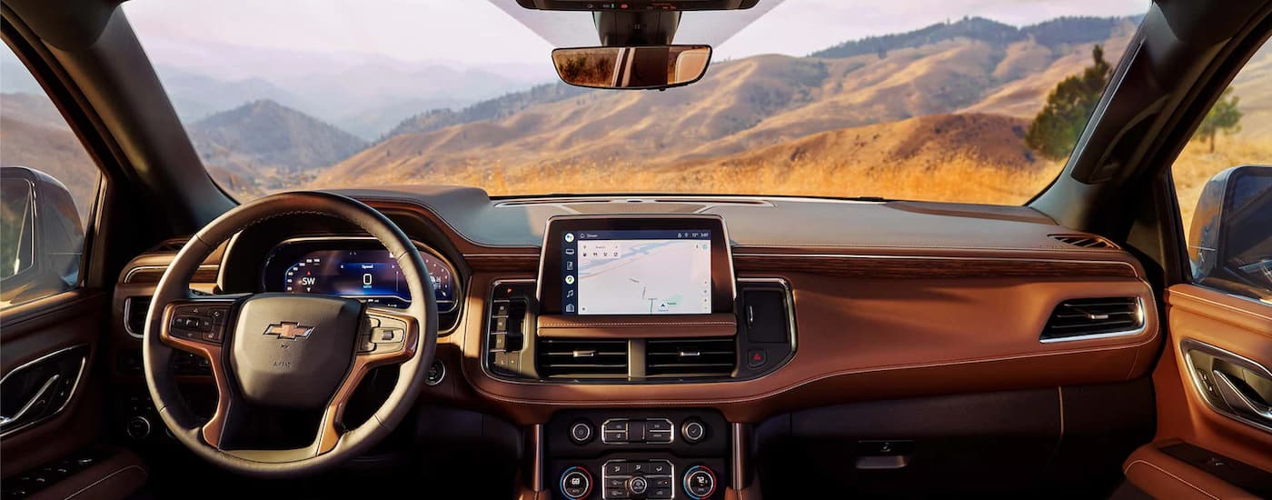 The black and brown 2023 Chevy Suburban shows the steering wheel and center console.