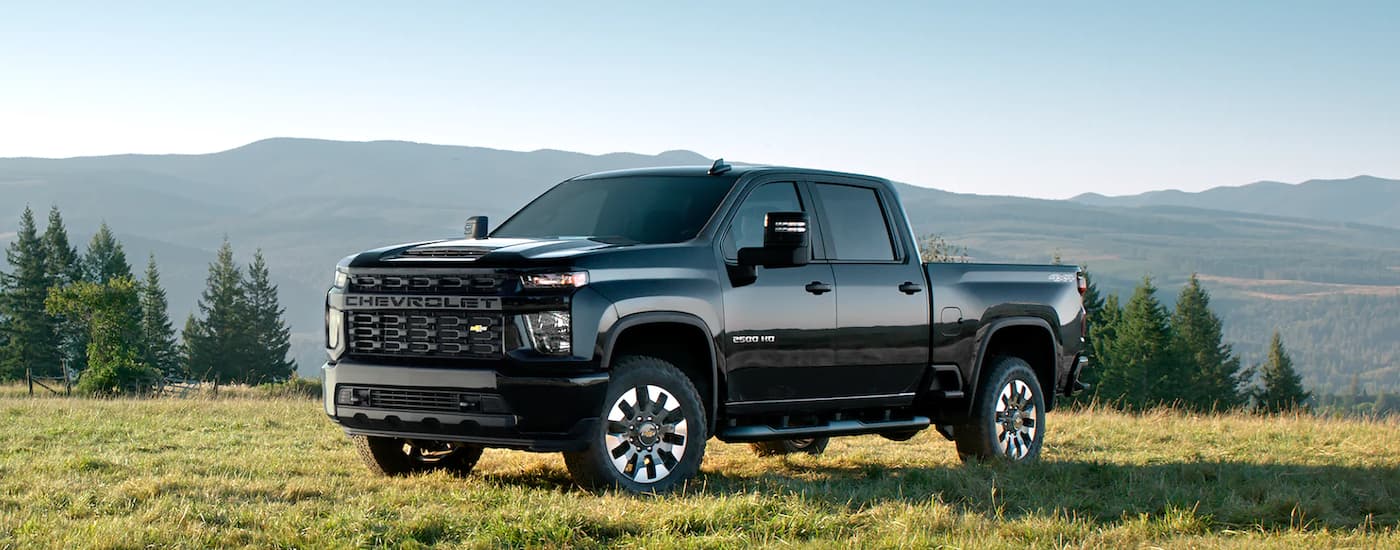 A black 2022 Chevy Silverado 2500 HD parked in a sunny field.