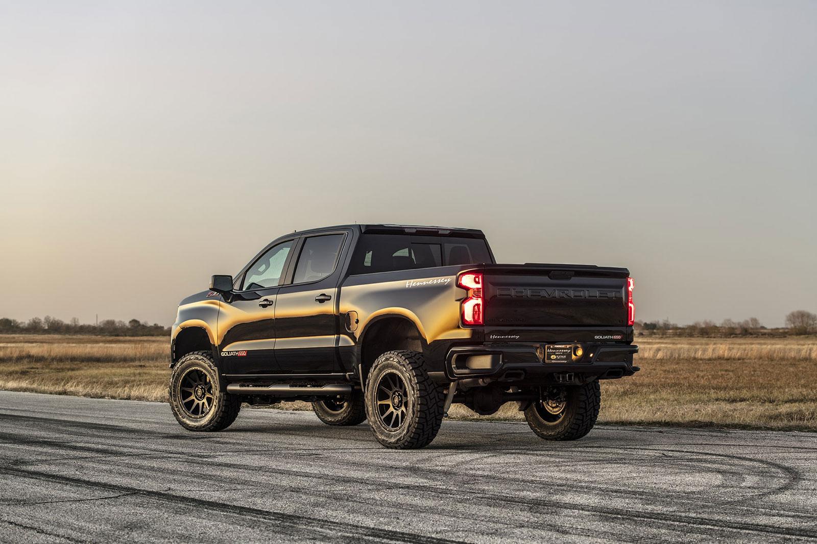 Shiny black Chevy Silverado with Hennessey Goliath  650 Supercharged upgrades, from rear driver's side