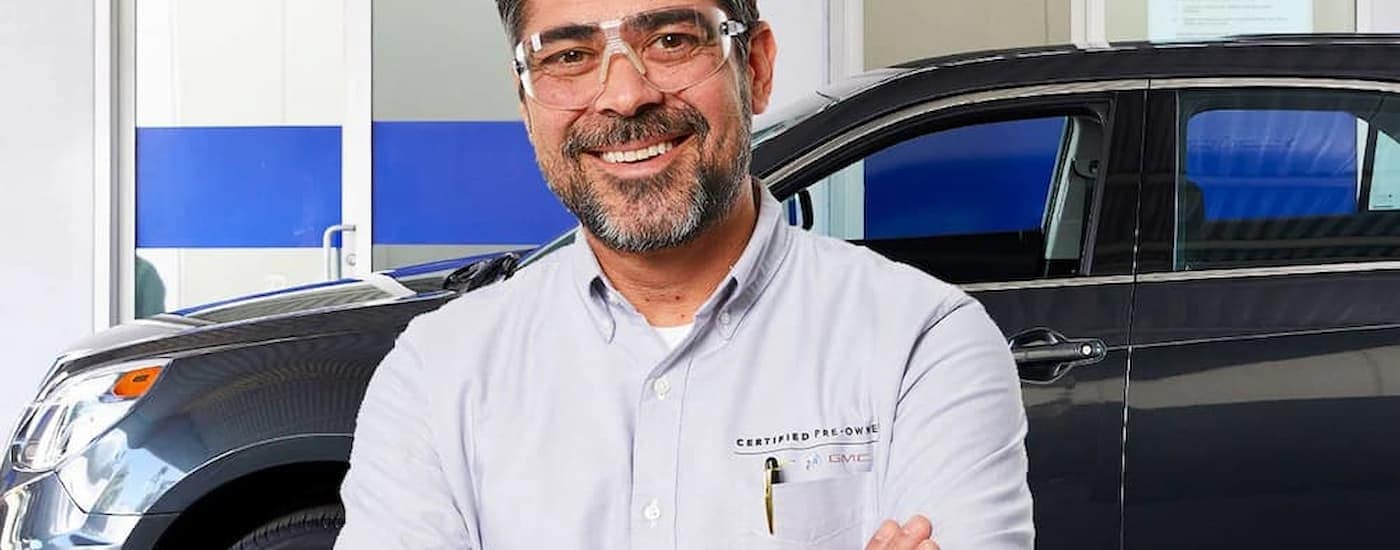 A Chevy mechanic is shown standing inside of repair shop.
