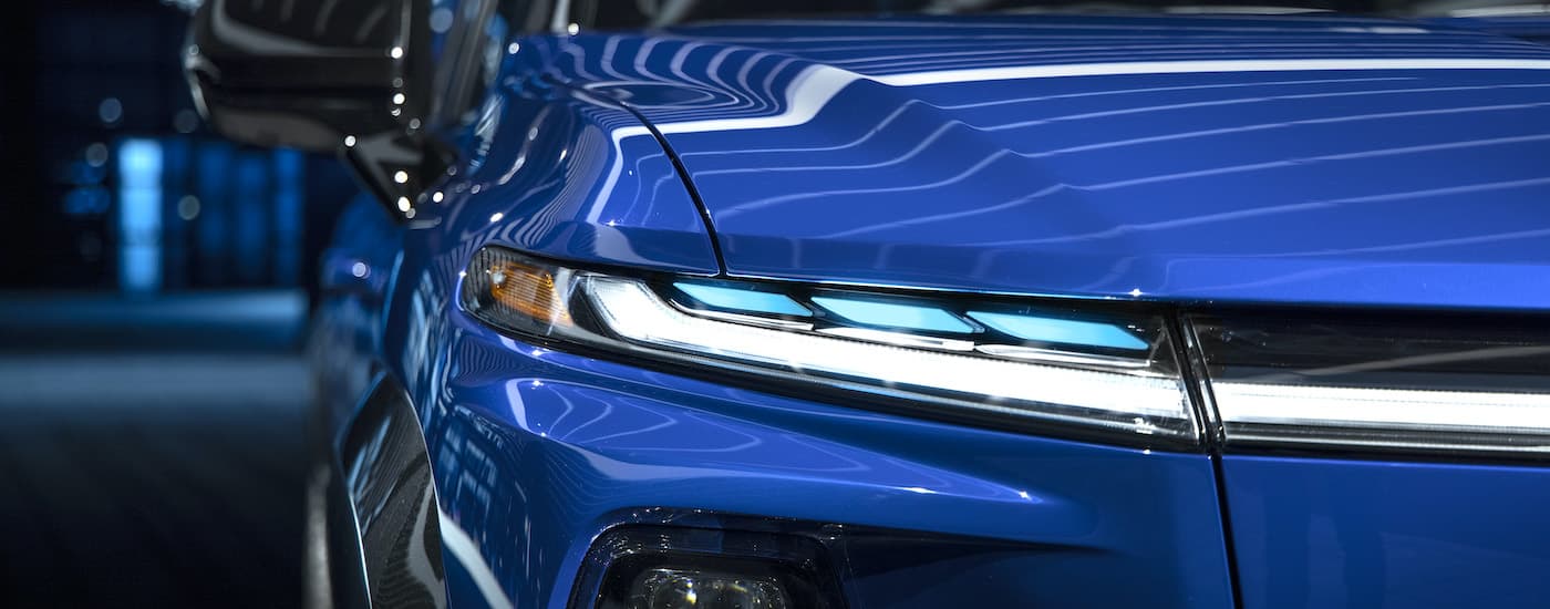 A close up shows the drive side headlight on a blue 2024 Chevy Silverado EV RST.