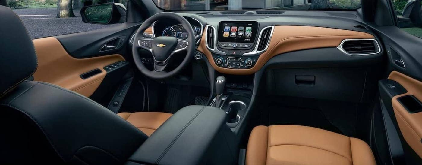 The brown and black leather interior of a 2023 Chevy Equinox.