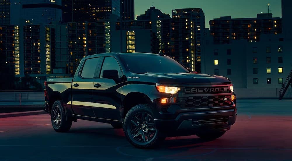 A black 2024 Chevy Silverado Custom for sale near Rancho Cordova is shown from the front at an angle.