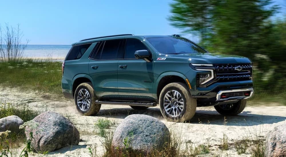  A green 2025 Chevy Tahoe Z71 is shown parked near an ocean.
