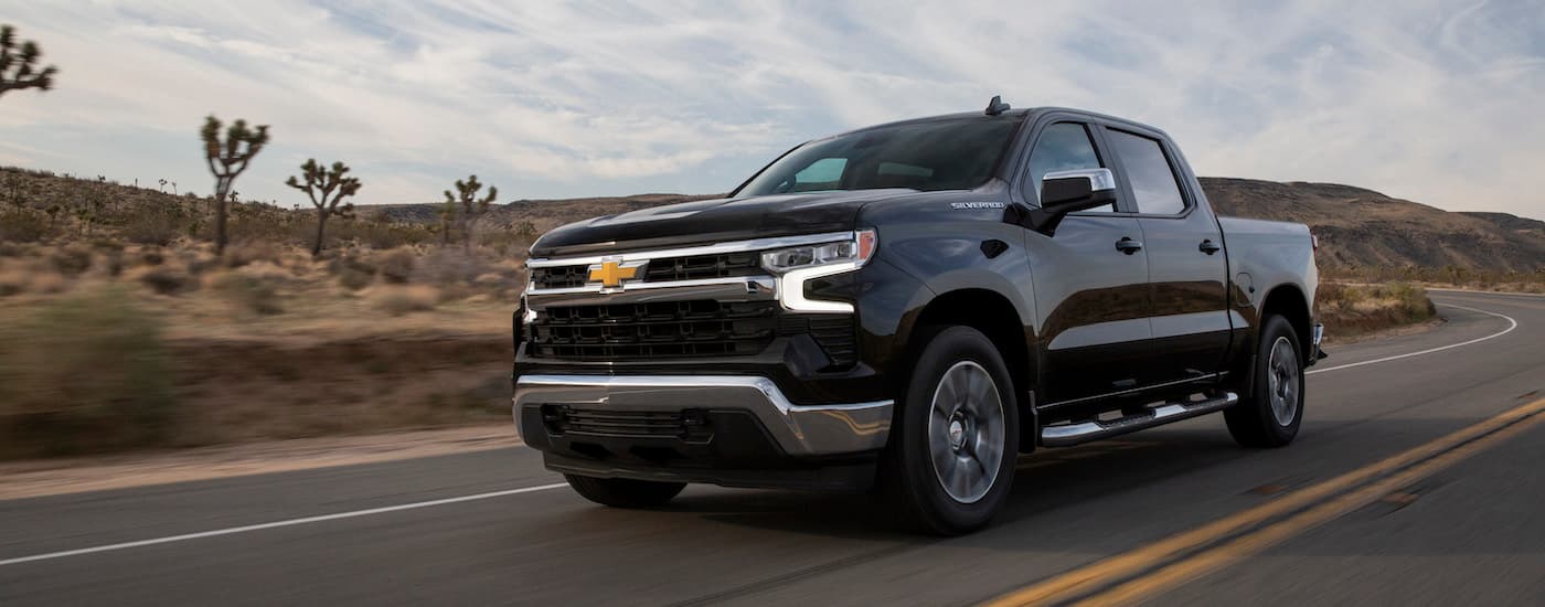 A black 2022 Chevy Silverado 1500 is shown from the front at an angle after leaving a used Chevy dealer.