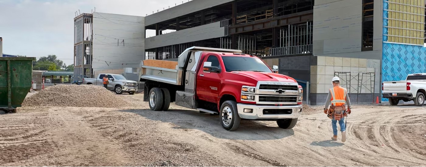 A red 2024 Chevy Silverado 5500 HD is shown parked on a construction site.