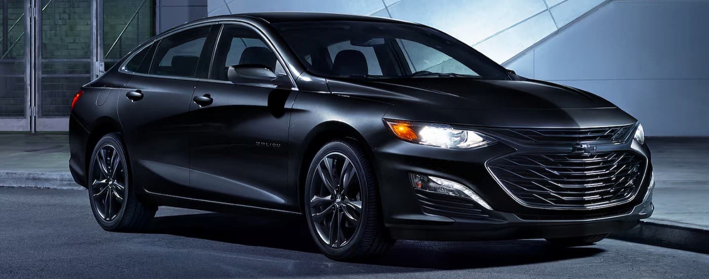 A black 2024 Chevy Malibu Midnight Edition is shown parked at night.