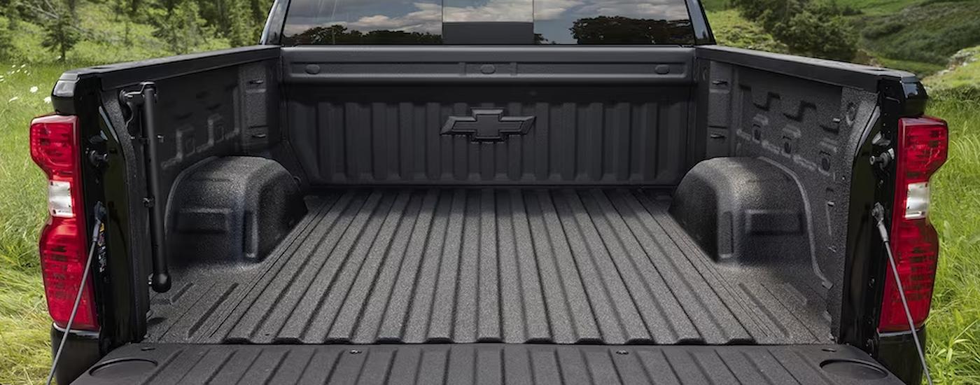 The bed of a black 2023 Chevy Silverado 1500 Custom is shown from the rear.