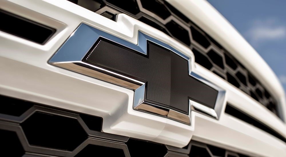 Close-up of the Chevy badge on the grille of a white 2015 Chevy Silverado1500 Rally Edition.