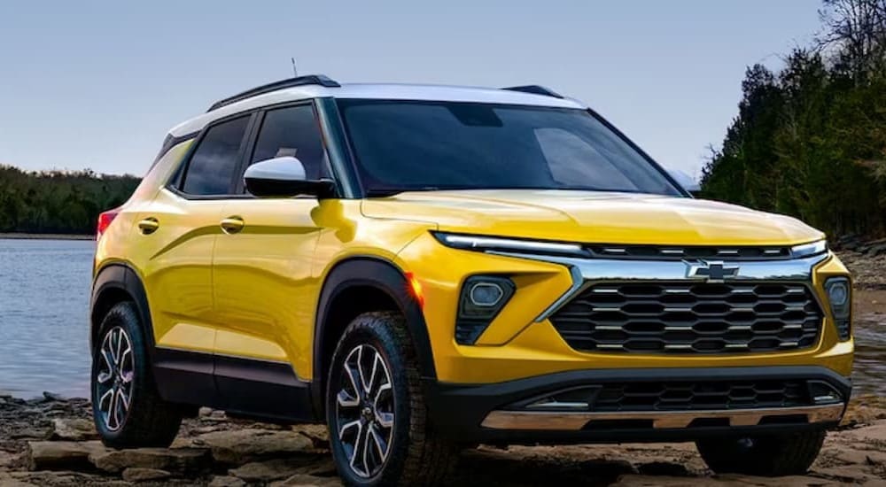 A yellow 2024 Chevy Trailblazer is shown parked near an ocean.