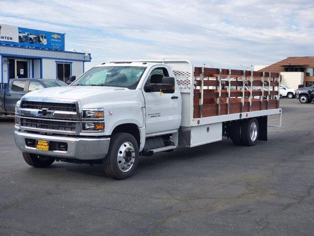 Front view of a white Chevy Silverado 5500HD with 18 ft Scelzi flat bed and dark wood stake sides