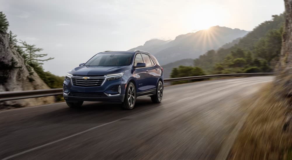 A blue 2022 Chevy Equinox Premier is shown from the front at an angle after leaving a dealer that has used Chevy SUVs for sale.