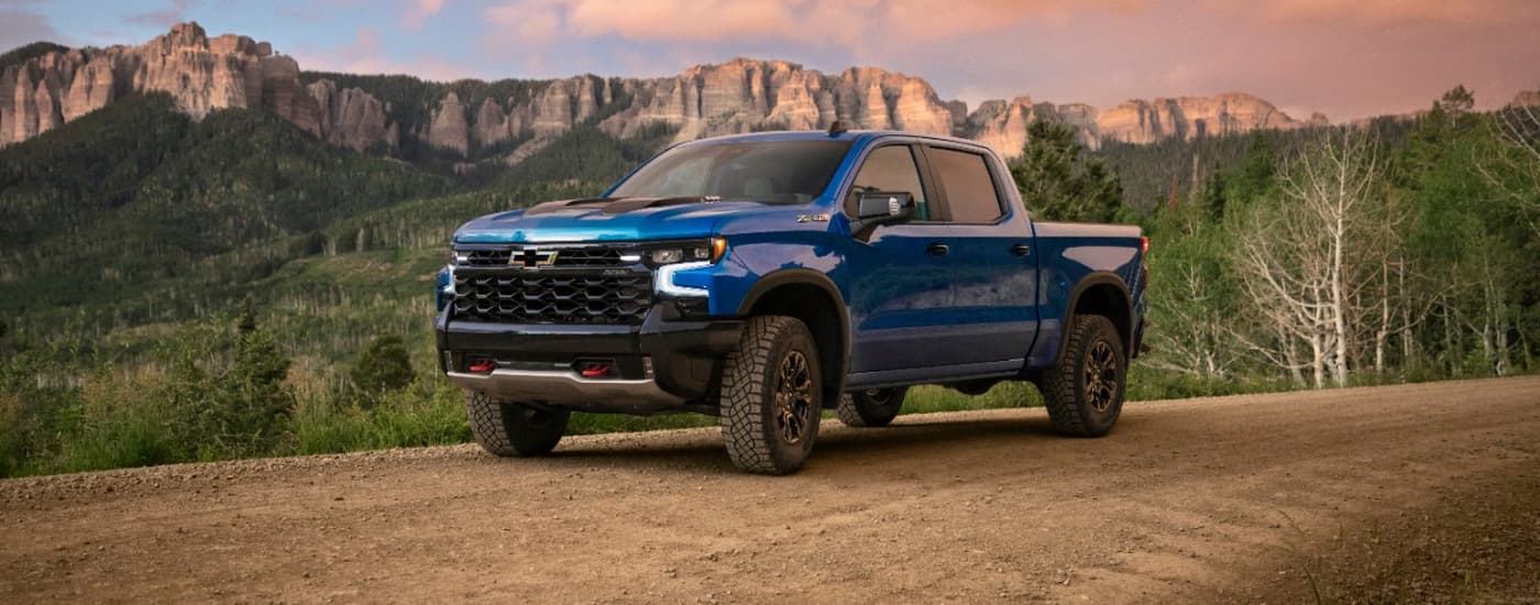 Chevy Silverado for Sale - 2022 Chevy Silverado ZR2 - Blue Dirt Road.jpg A blue 2022 Chevy Silverado 1500 ZR2 parked in front of tall cliffs.