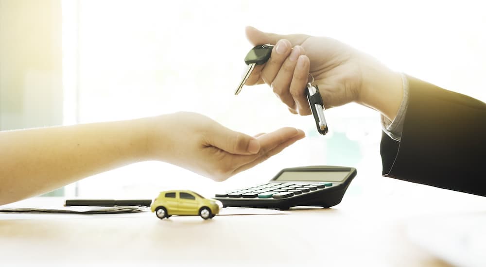 Close-up of handing over new car keys after securing auto financing