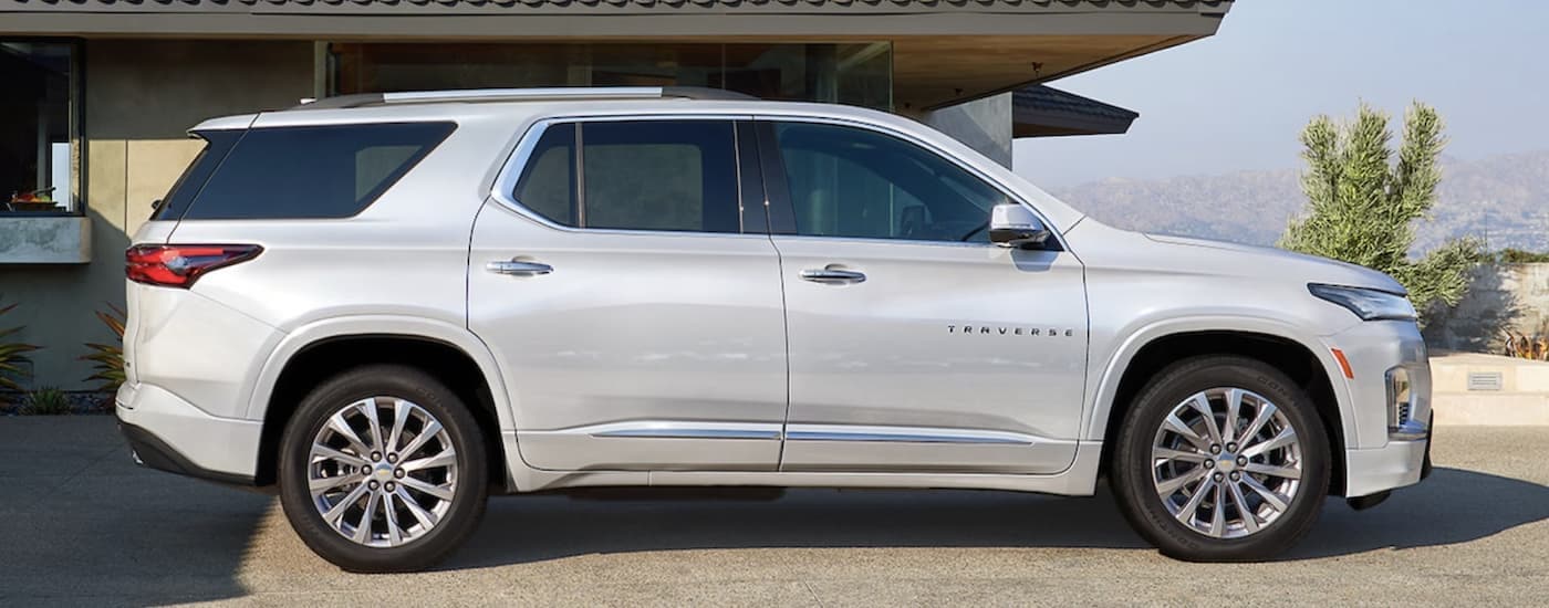 A white 2023 Chevy Traverse is shown from the side parked in a driveway.