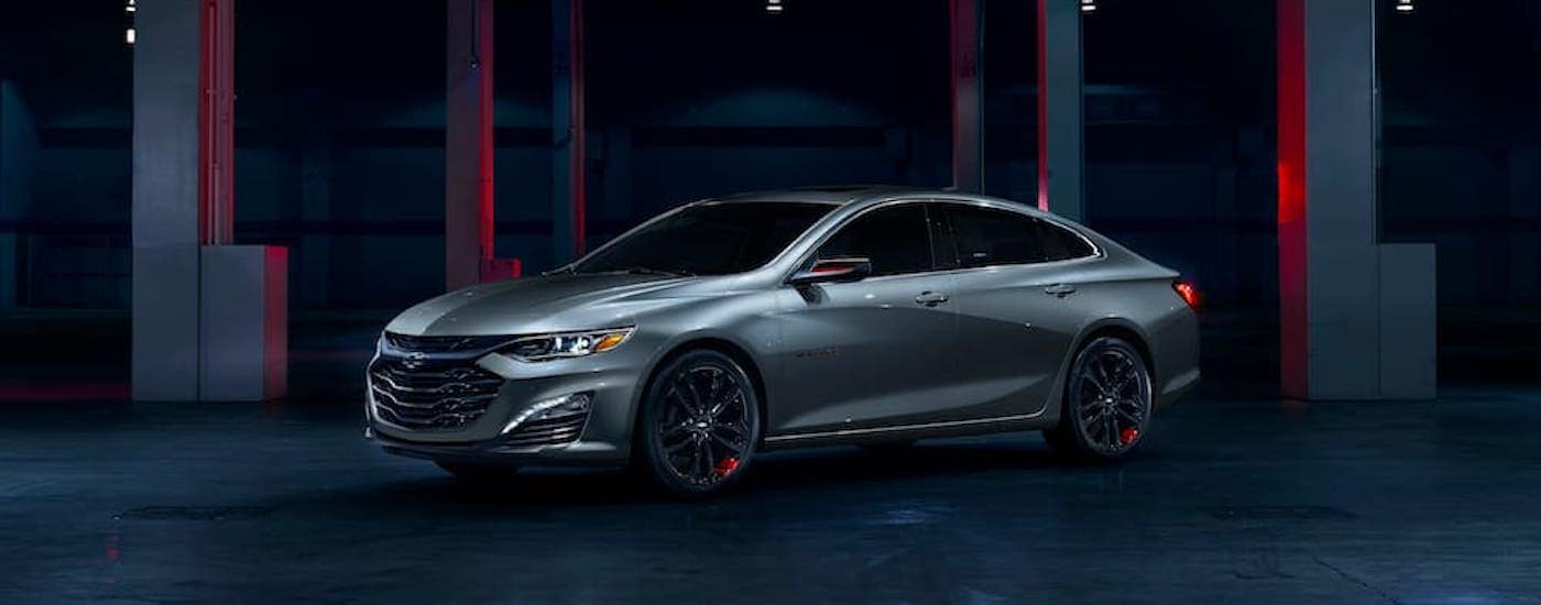 A silver 2024 Chevy Malibu Redline is shown from the side at an angle after leaving a Chevy dealer near Antelope.