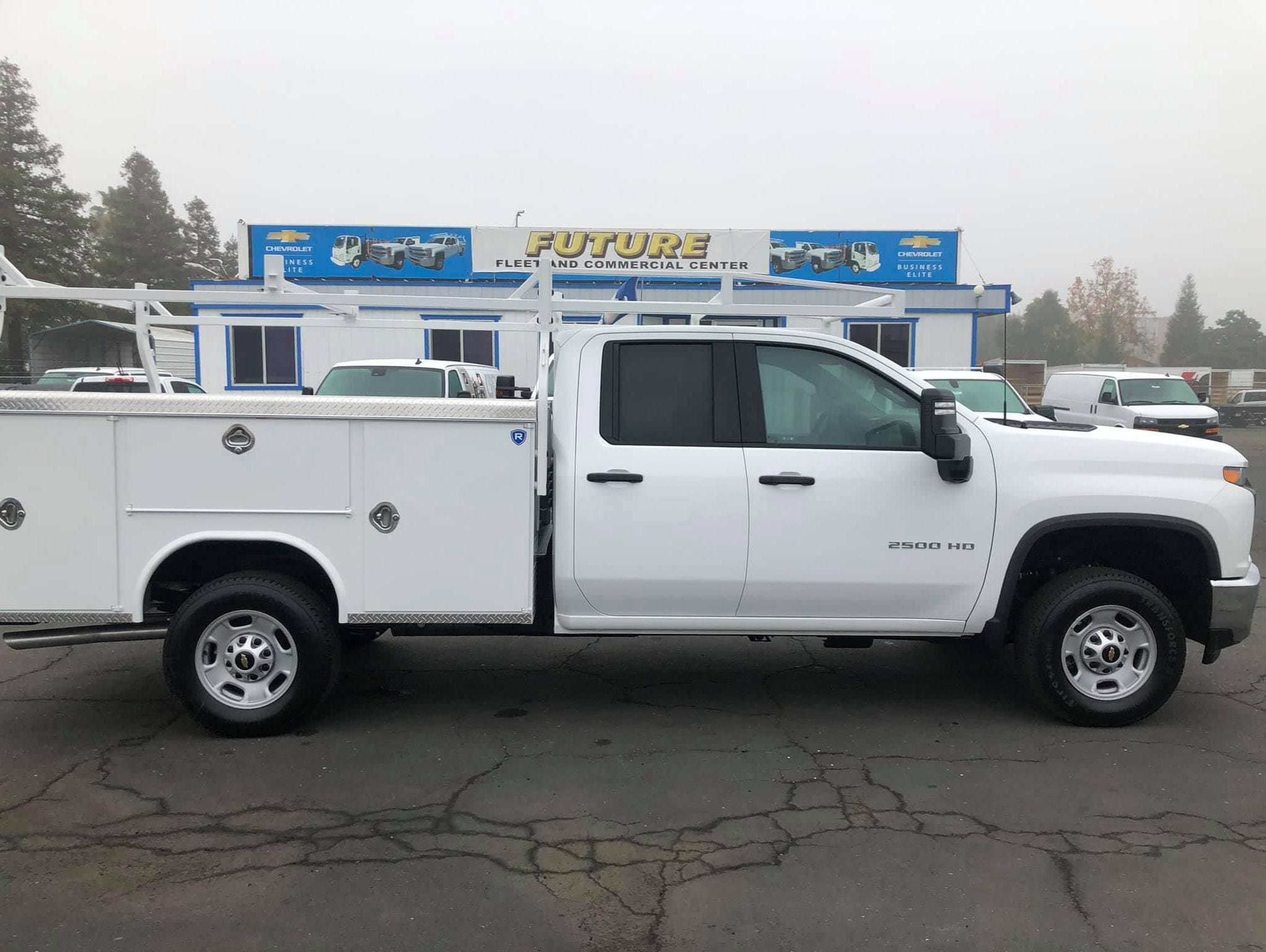 Side view of a white Chevy Silverado 2500HD double cab with Royal service body